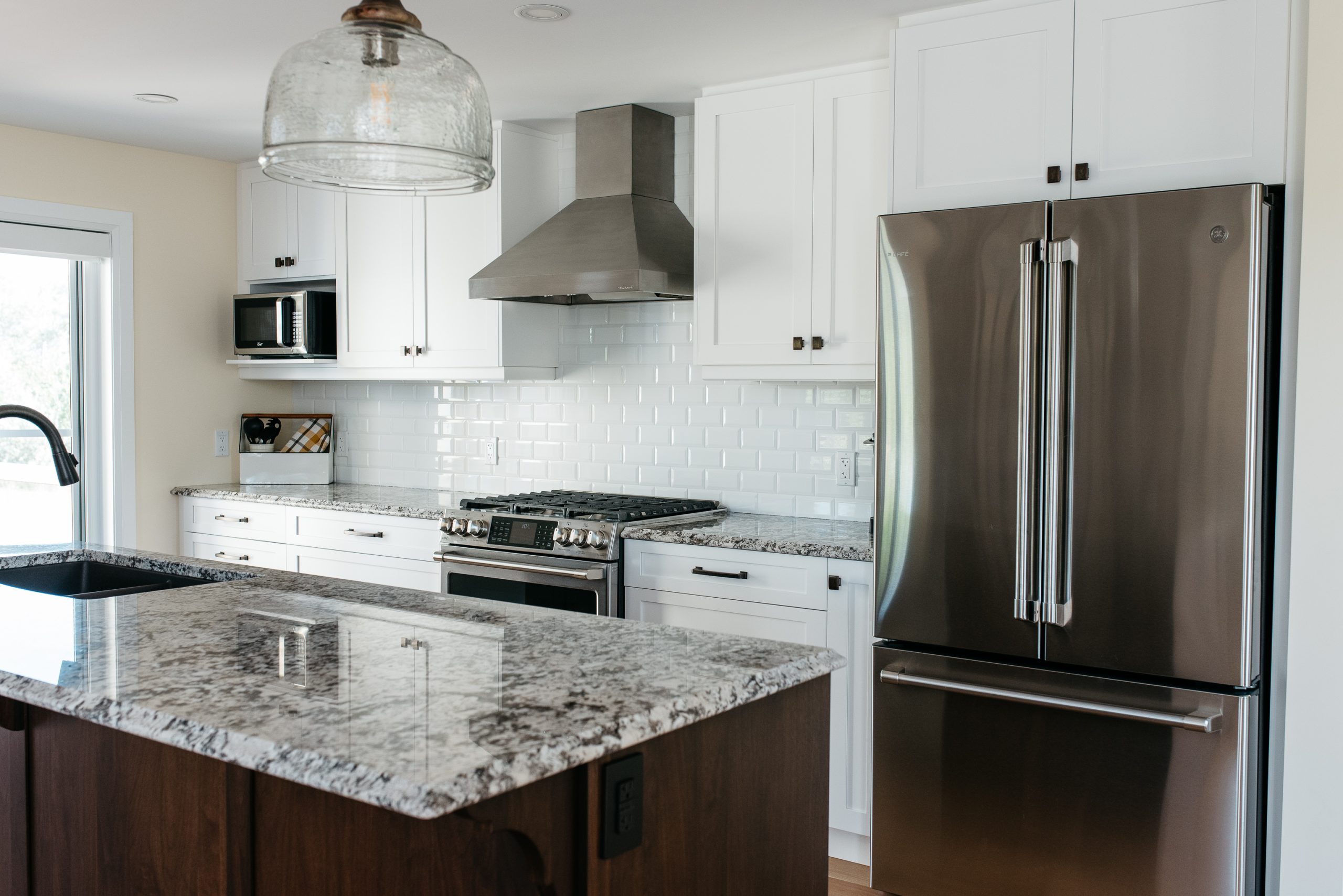 A gorgeous open-concept kitchen remodel featuring custom cabinetry and island by SSP Cabinetry and Millwork