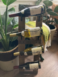 Whiskey barrel wine rack fitted with four wine bottles